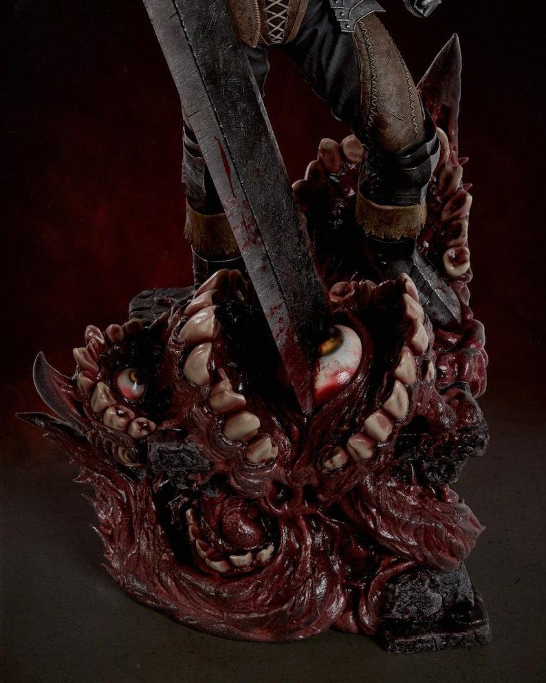 May include: A detailed collectible statue featuring a dark, weathered sword blade piercing a grotesque, fleshy base covered in numerous human-like teeth and bloodshot eyes. The figure wears dark trousers and armored boots, standing atop the mass.