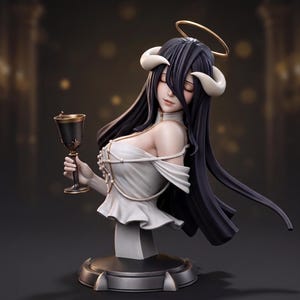 May include: A bust figurine of a character with long black hair, curved horns, and a gold halo. The figure wears a white off-the-shoulder top with gold accents and holds a black and gold chalice. The sculpture is mounted on a circular base.