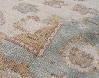 hand-knotted wool area rug features a muted ivory and silver palette with large-scale floral and geometric motifs 6x9,8x10,9x12,10x14,12x15,
