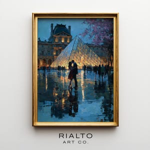 May include: A framed art print depicts a couple kissing in front of the Louvre Museum in Paris. The artwork features a glass pyramid, a historic building, and a reflective, wet surface. The painting has a gold frame and the text "RIALTO ART CO."