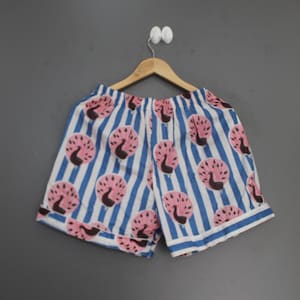 May include: A pair of shorts featuring a pattern of dark brown and pink peacock motifs set against a background of vertical blue and white stripes. The shorts have an elasticized waistband and a hemmed finish at the bottom of each leg opening.