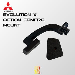 Puede incluir: Un soporte de cámara de acción negro para Mitsubishi Evolution X que presenta un brazo curvo con un soporte de montaje en un extremo y una base plana en el otro, acompañado de una placa negra texturizada separada con un orificio central.