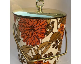Cubitera vintage con estampado floral, tapa dorada y asa, con flores naranjas, estilo años 60 y 70.