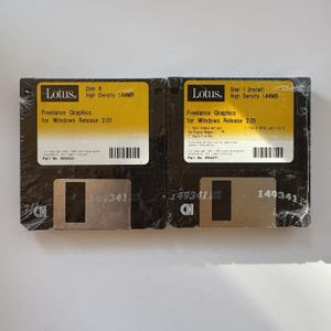 May include: Two vintage black 3.5-inch floppy disks, still in their original packaging. Each disk has a yellow label with the "Lotus" logo and the text "Freelance Graphics for Windows Release 2.01". The disks are labeled "Disk 6" and "Disk 1 (Install)".