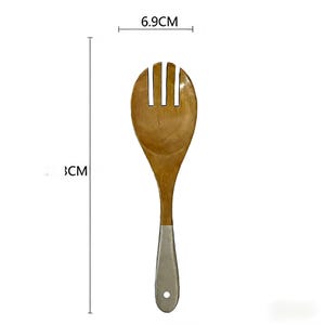 May include: Wooden salad spoon with a light brown finish and a silver-coloured handle. The spoon head is 6.9 cm wide and the spoon is 33 cm long. The spoon has a slotted design, ideal for serving salads.
