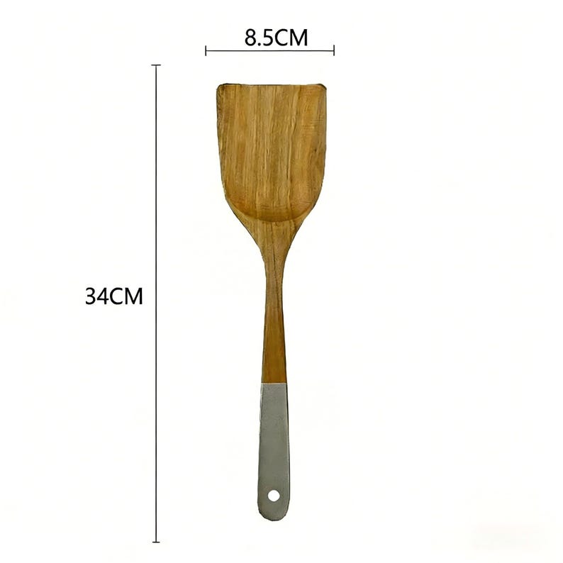 May include: A wooden spatula, 34cm long and 8.5cm wide, with a light brown wooden head and handle. The handle has a silver-coloured metal base with a hole for hanging. The spatula is designed for cooking and food preparation.
