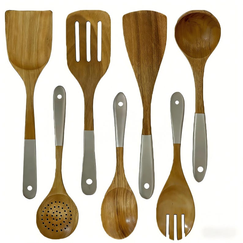 May include: A set of wooden kitchen utensils, including a spatula, slotted spatula, spoon, ladle, slotted spoon, serving spoon, and fork. Each utensil has a natural wood finish with a silver-coloured handle.