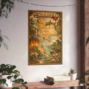 May include: A vintage-style map of Thailand, featuring detailed illustrations of landmarks, temples, and landscapes. The map includes the Thai flag and the country's name. The map is framed and mounted on a white wall, with a wooden shelf below.
