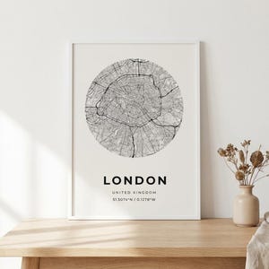 Puede incluir: Una lámina de arte enmarcada que presenta un mapa circular en blanco y negro de Londres, Reino Unido. El texto debajo del mapa dice LONDON, UNITED KINGDOM, y las coordenadas 51.5074°N / 0.1278°W en una fuente negra sin remates.