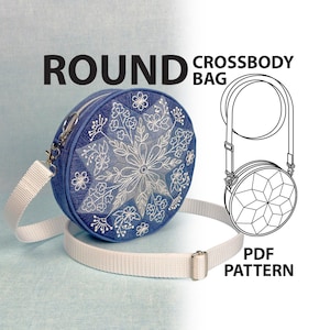 May include: A round crossbody bag featuring a blue fabric exterior with white floral embroidery in a geometric star pattern, a white adjustable strap, and a silver zipper. The text ROUND CROSSBODY BAG PDF PATTERN is visible alongside a line drawing.