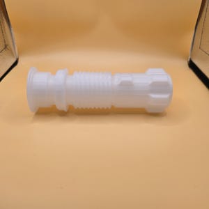 Pu&ograve; includere: Un'elsa di spada laser bianca stampata in 3D. L'elsa presenta un design cilindrico con sezioni a coste e strutturate e un pomello dettagliato. Il design generale ricorda un'arma fantascientifica.