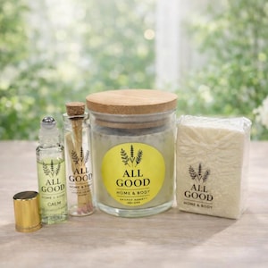 May include: An assortment of "All Good Home & Body" products, including a glass jar candle with a wooden lid, a small roller bottle, a glass vial, and a wrapped bar of soap. The products have yellow labels with a lavender sprig design.
