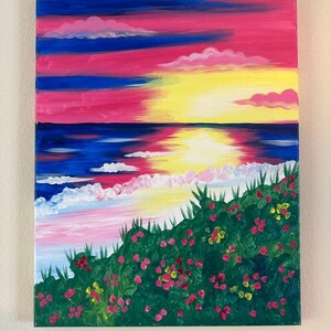 May include: Acrylic painting of a sunset over the ocean. The sky is a mix of pink, blue, and yellow hues. The ocean is dark blue with white waves. A green hillside with pink and yellow flowers is in the foreground.