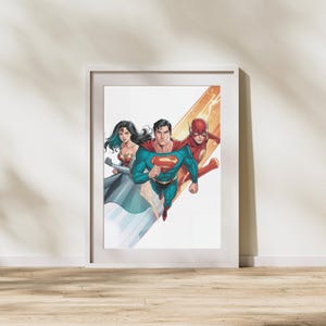 Può includere: Stampa incorniciata con Superman, Wonder Woman e Flash in pose dinamiche. Superman indossa un costume blu e rosso, Wonder Woman un abito oro e rosso e Flash un costume rosso. L'opera d'arte è in stile fumetto.