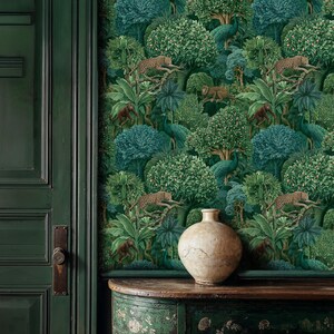 Pode incluir: Um design de papel de parede detalhado com uma exuberante cena da selva com leopardos, macacos e pavões em meio a folhagens densas. A paleta de cores inclui tons de verde e verde-azulado. Um vaso creme repousa sobre uma mesa verde-escura.