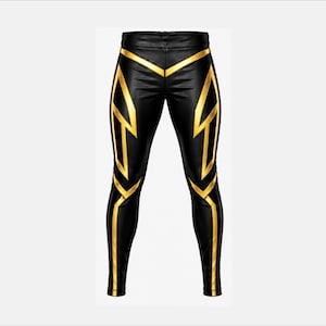May include: Black leggings featuring a bold, geometric gold pattern that runs along the thighs and down the legs. The design includes sharp, angular lines and symmetrical shapes that create a striking contrast against the solid black fabric base.