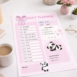 Può includere: Un'agenda giornaliera rosa con un'illustrazione di fiocco in alto. L'agenda include un programma, promemoria e priorità principali. Sono presenti illustrazioni di panda. Una tazza di caffè, occhiali e un telefono sono sul tavolo.