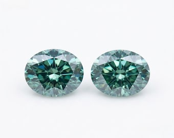 May include: Two oval-cut gemstones with a deep teal and blue-green color. Each stone features a faceted surface that creates a star-like pattern of light reflection, showcasing a brilliant sparkle and a transparent, polished appearance.