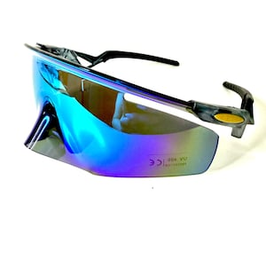 May include: Sport sunglasses with a blue-purple gradient lens and black frames. The sunglasses have a wraparound design and curved temples for a secure fit. The lenses have a mirrored finish and UV 400 protection.