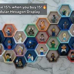 May include: A modular hexagon display with various colorful frames, each housing a different miniature figurine. The frames are in shades of orange, green, blue, and black. Text in the upper left corner reads "Save 15% when you buy 15! Modular Hexagon Display."