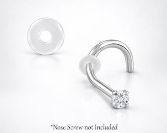 May include: A silver-toned nose screw featuring a clear, round, faceted gemstone set in a prong setting. The jewelry includes a small, translucent silicone disc. The text *Nose Screw not Included is visible at the bottom of the image.