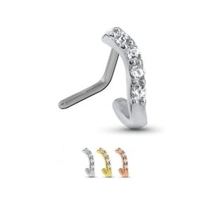 May include: A silver nose ring with a curved bar and a row of clear cubic zirconia stones. The ring is also available in gold and rose gold.