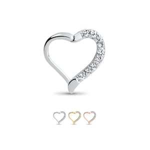 Può includere: Un orecchino a cerchio in argento a forma di cuore con una fila di pietre di zircone cubico trasparenti lungo il bordo superiore. L'orecchino è disponibile in argento, oro e oro rosa.