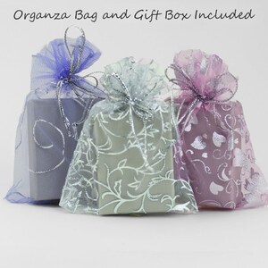 May include: Three gift boxes wrapped in sheer fabric with silver accents. The boxes are in shades of blue, green, and pink.  "Organza Bag and Gift Box Included" is written at the top of the image.