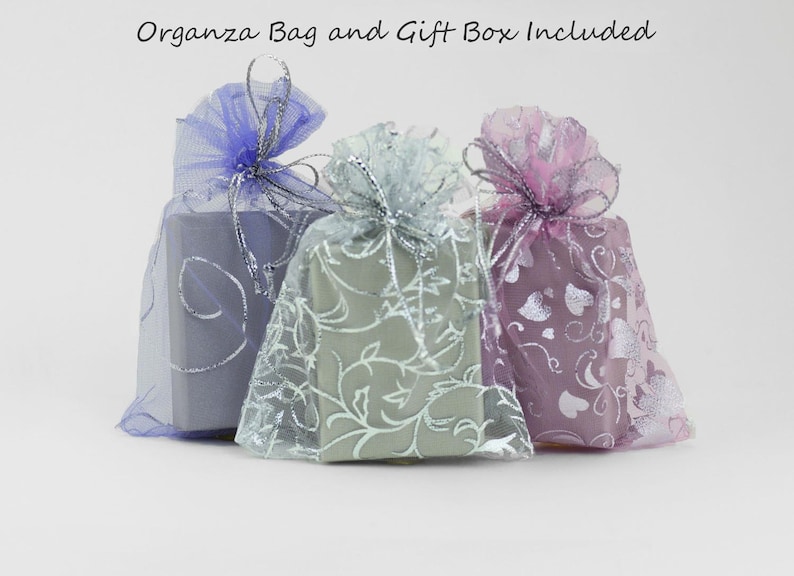 May include: Three gift boxes wrapped in sheer fabric with silver accents. The boxes are in shades of blue, green, and pink.  "Organza Bag and Gift Box Included" is written at the top of the image.