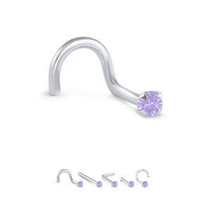 Puede incluir: Un aro de nariz de plata con una pequeña piedra redonda de color lavanda. El aro es curvo y tiene un pequeño bucle en el extremo.