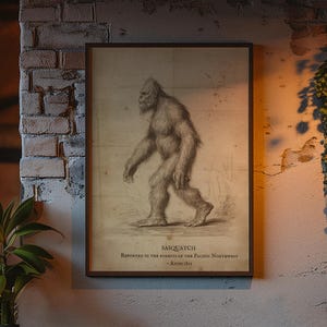 May include: A framed rectangular wall print featuring a detailed sketch of a Sasquatch in profile. The text below the creature reads SASQUATCH, RESIDENT OF THE FORESTS OF THE PACIFIC NORTHWEST, ESTABLISHED 1967. The print has a beige background.