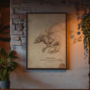 May include: A framed rectangular print featuring a detailed pencil-style sketch of a winged creature. The text below the illustration reads JERSEY DEVIL, OBSERVED IN THE PINE BARRENS, NEW JERSEY, - CIRCA 1735. The print is displayed on a textured brick wall.