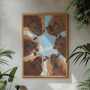 May include: A framed art print featuring a group of capybaras looking down at the viewer. The capybaras are depicted with light brown fur and are set against a blue sky with fluffy white clouds. The frame is a warm, light brown color.