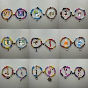 May include: A selection of beaded bracelets, each showcasing a different cartoon character. The bracelets are linked by a gold-coloured charm and include a star or heart charm. They are made with colourful beads and are displayed on a white surface.