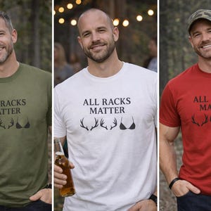 May include: Three men wearing t-shirts with the text "ALL RACKS MATTER" and a graphic of antlers and a bra. The shirts are olive green, white, and red. The men are smiling and wearing dark-colored pants.