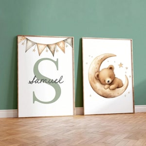 May include: Two framed nursery art prints. One features a large green letter "S" with the name "Samuel" in script, and a banner of pennants. The other shows a sleeping teddy bear on a crescent moon with stars.