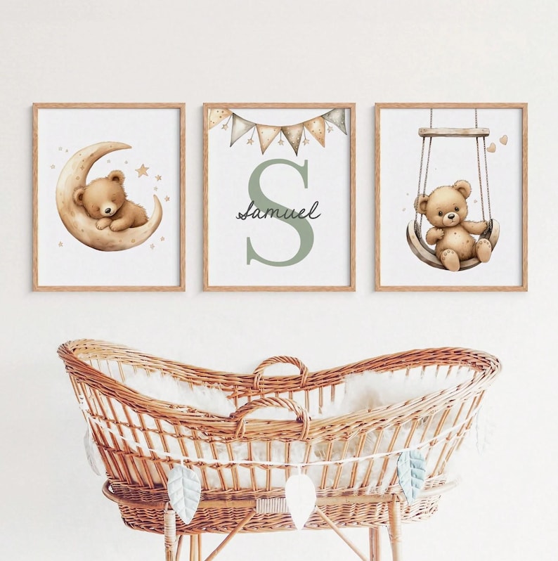 May include: Three framed nursery art prints. One features a teddy bear on a crescent moon, another displays the name "Samuel" with a large letter "S", and the third shows a teddy bear on a swing. The frames are light brown.