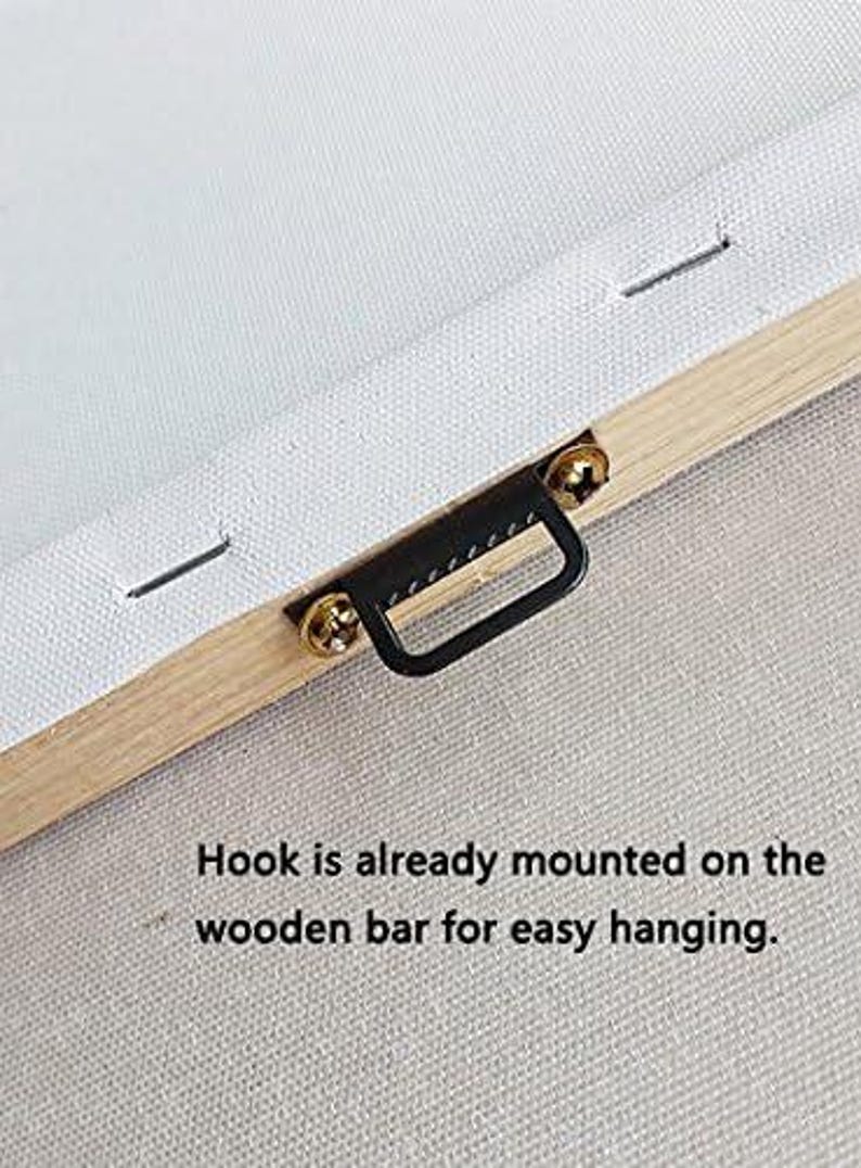 May include: Close-up of a canvas print's wooden frame with a pre-installed black metal hook. The canvas is white, and the frame is light brown. The text reads: "Hook is already mounted on the wooden bar for easy hanging."
