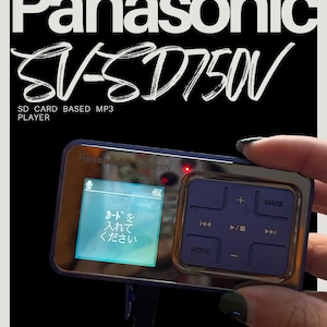 May include: A Panasonic SV-SD750V SD card-based MP3 player. The device has a blue and silver casing with a screen displaying Japanese text. It features control buttons and the Panasonic logo.