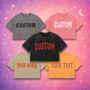 Op de afbeelding: Vijf T-shirts met korte mouwen en een korte snit in grijs, roze, zwart, beige en oranje. Het grijze shirt heeft zwarte tekst met CUSTOM. Het roze shirt heeft witte tekst met CUSTOM. Het zwarte shirt heeft rode tekst met CUSTOM. Het beige shirt heeft oranje tekst met YOUR WORDS. Het oranje shirt heeft paarse tekst met YOUR TEXT.