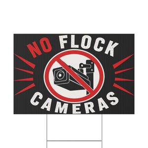 May include: A rectangular yard sign with a black background and white vertical stripes. It features a red circle with a diagonal line over a black security camera icon. The text reads NO FLOCK CAMERAS in bold white and red capital letters.