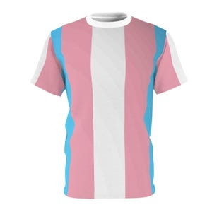 May include: A short-sleeved t-shirt featuring a vertical striped design in pink, white, and light blue. The shirt has a white crew neck and white accents on the sleeves. The design is a representation of the transgender pride flag.
