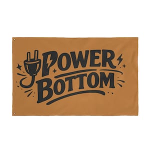 Puede incluir: Bandera rectangular, de color marrón, con las palabras "POWER BOTTOM" en letras negras estilizadas. Un gráfico de enchufe negro está a la izquierda, con un rayo y estrellas. La bandera tiene ojales en las esquinas.