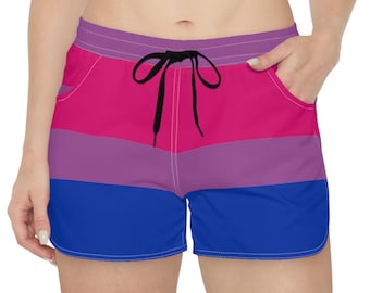 Pode incluir: Calções desportivos com um padrão tricolor horizontal em rosa brilhante, roxo e azul. Os calções têm uma cintura elástica roxa com um cordão preto, bolsos laterais e costuras brancas ao longo das bainhas e aberturas curvas das pernas.
