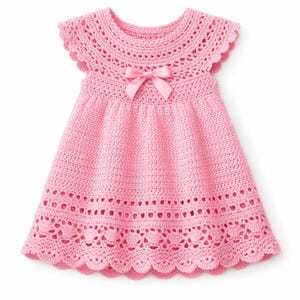 Può includere: Un vestito rosa all'uncinetto con orlo smerlato e maniche a cappuccio. L'abito presenta un motivo traforato decorativo intorno allo scollo e all'orlo. Un fiocco rosa è centrato sul corpetto. L'abito è progettato per un bambino o un bambino piccolo.