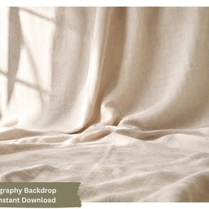 Może przedstawiać: Beżowe tło fotograficzne z tkaniny o teksturowanej, tkanej powierzchni z miękkimi fałdami. Materiał ma neutralny, jasnobrązowy kolor z naturalnymi cieniami rzucanymi na tkaninę, tworząc subtelny wzór ramy okiennej.