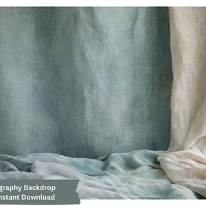 Puede incluir: Un fondo de fotografía con una superficie texturizada y moteada de color azul verdoso, drapeada con una tela suave de color blanco roto. La escena incluye una tela de color azul verdoso claro drapeada en la base, creando una composición.