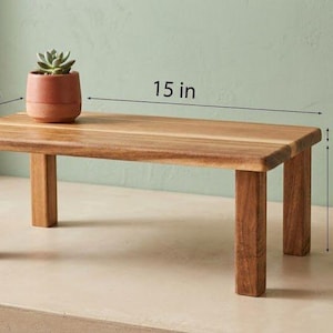 Op de afbeelding: Een kleine, rechthoekige houten tafel met vier poten. De tafel is 38,1 cm lang, 26,9 cm breed en 14 cm hoog. Een kleine terracotta pot met een vetplant staat op de tafel. Een kleine kom en lepel liggen op het aanrecht.