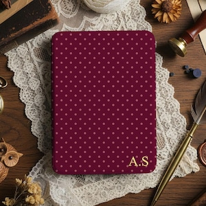 May include: A burgundy notebook with a polka dot pattern and gold initials "A.S." is displayed on a wooden surface. The scene includes a pocket watch, a carved owl, a quill pen, and a wax seal, suggesting a vintage or antique theme.