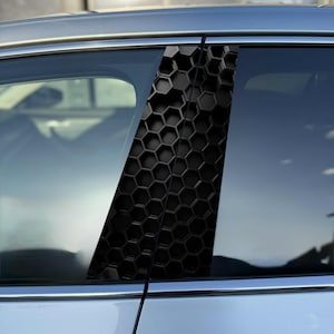 Könnte beinhalten: Eine schwarze B-Säulen-Verkleidung für Autos mit einem erhabenen, dreidimensionalen Wabenmuster. Das Zubehörteil ist auf dem vertikalen B-Säulen-Abschnitt zwischen den Seitenfenstern eines silbernen Fahrzeugs angebracht und bietet eine Textur.